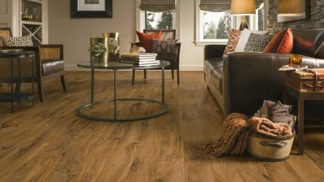 Luxury vinyl plank flooring in a modern living room setting, showcasing a warm wood finish, complemented by stylish furniture and decor, highlighting the aesthetic appeal of LVP installation.